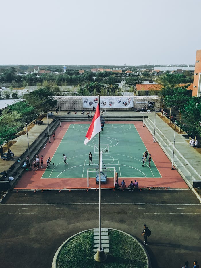 Aerial view of students playing basketball on an outdoor court in Jawa Tengah, Indonesia.